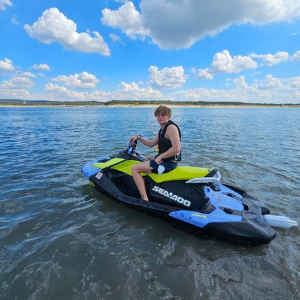 Man riding blue and yellow Yamaha jet ski on Canyon Lake Texas
